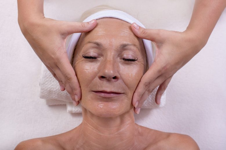 A senior female relaxing in the spa during the facial massage